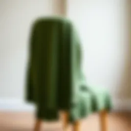 Elegant green cardigan draped over a chair showcasing its texture