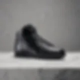 Sleek silhouette of black Nike shoes on a marble surface