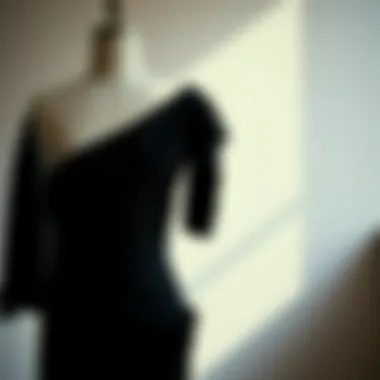 Elegant one-shoulder black dress draped on a mannequin showcasing its silhouette.